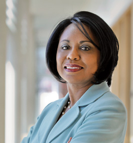 Portrait of Anita Hill standing in long hallway.